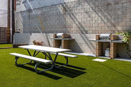 a picnic table and a bench in a backyard