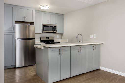 A kitchen with a stainless steel refrigerator and a white countertop.