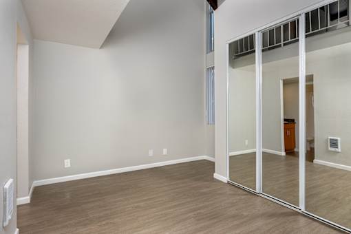 A room with a white wall and wooden floor.