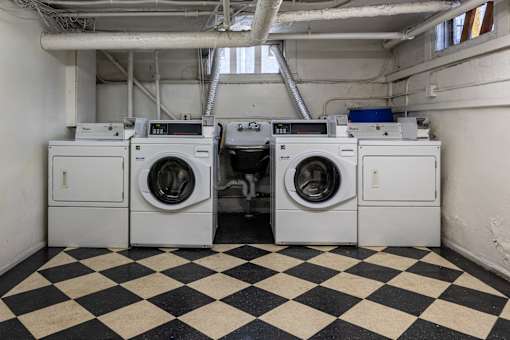 a row of washing machines in a laundry room with checkered floors