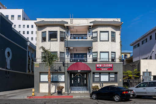 a building with a red awning and a car parked in front of it