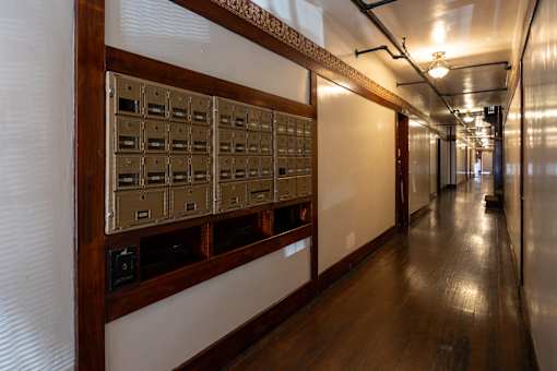 a view of a long hallway with rows of mailboxes on the wall