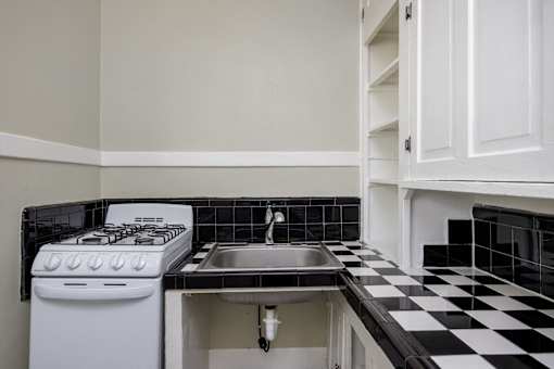 a kitchen with black and white checkered floor and a stove and sink