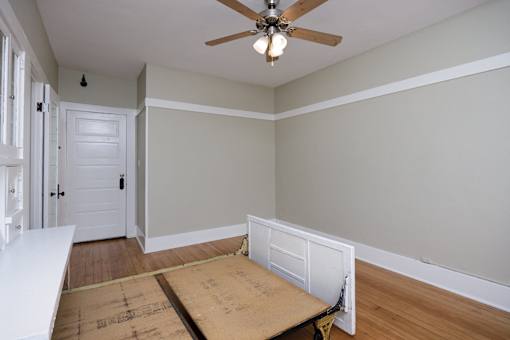 an empty room with a desk and a ceiling fan