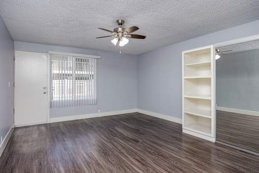 A room with a ceiling fan and a sliding door.