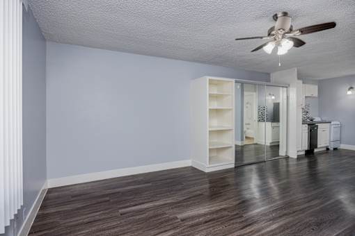 A room with a ceiling fan and a cabinet.