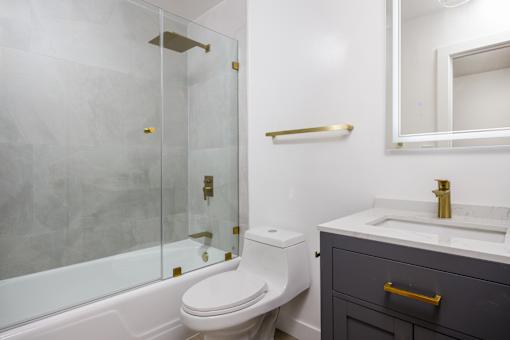 a bathroom with a toilet and a shower and a sink