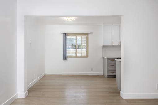 a living room with white walls and a window