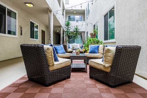 a patio with wicker furniture and a coffee table