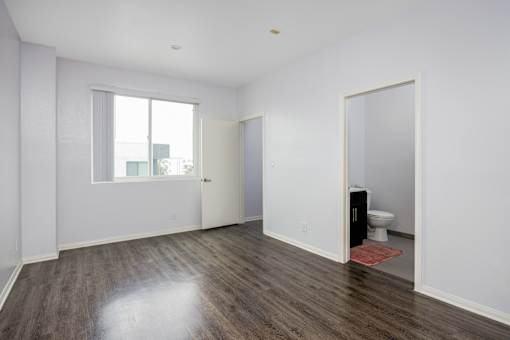 a living room with white walls and a door to a bathroom