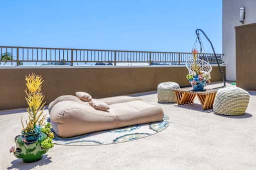 a terrace with a bean bag chair and tables on a roof