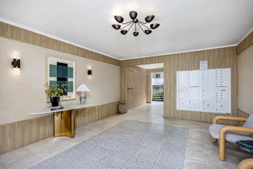 A waiting area with a white table, chairs, and a calendar on the wall.