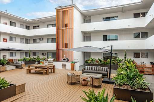 A modern building with a wooden deck and furniture.