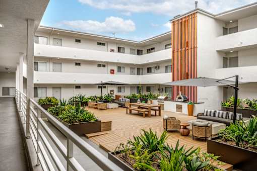 A modern building with a balcony and a garden area.