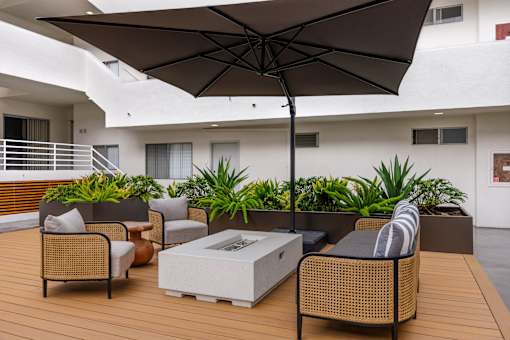 A patio with a table, chairs, and an umbrella.