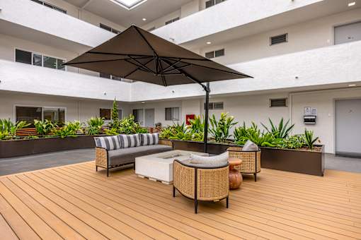 A patio with a couch and umbrella.