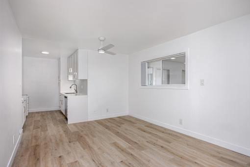 A room with wooden flooring and white walls.