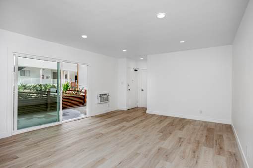 A room with wooden flooring and white walls.