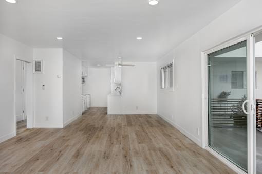 A room with wooden flooring and white walls.