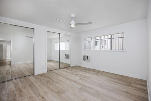 A room with a wooden floor and a ceiling fan.