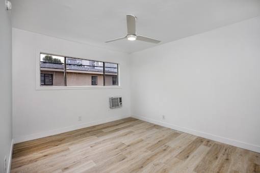 A room with a window and a fan on the ceiling.