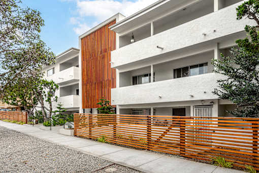 A modern building with a white facade and a wooden fence.