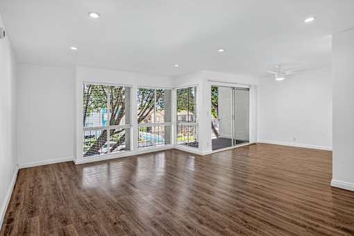 A room with wooden floors and sliding glass doors.