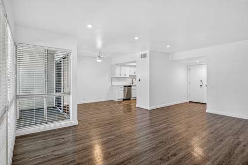 A spacious room with wooden floors and white walls.