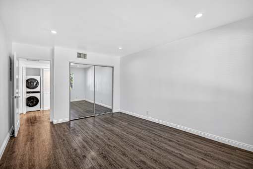 A room with a white wall and a wooden floor.