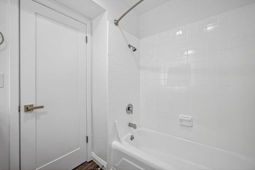 A white bathroom with a tub and shower.