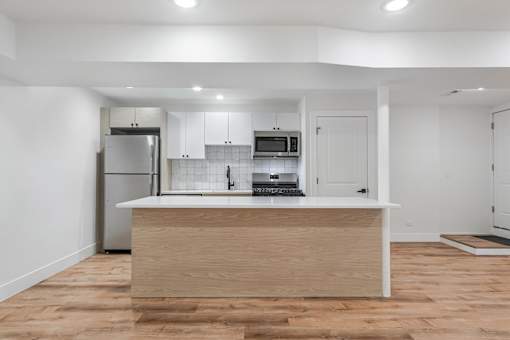 A kitchen with a wooden island and white walls.