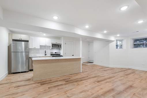 A kitchen with a refrigerator, microwave, and oven.