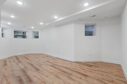 A room with wooden flooring and white walls.