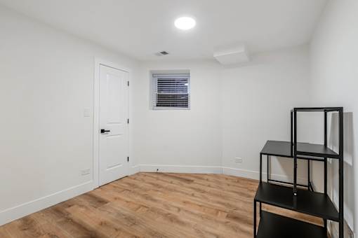 A room with a wooden floor and a white door.