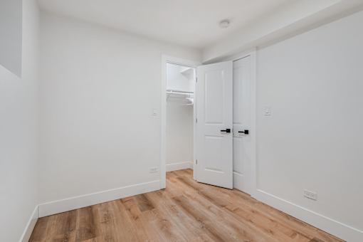 A white door is in a room with wood flooring.