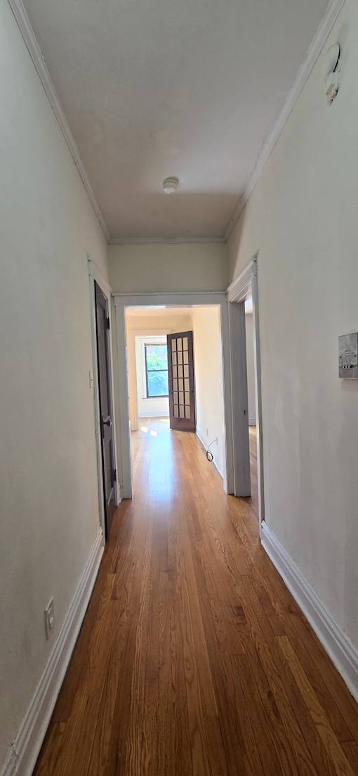 A room with a window and wooden wall.