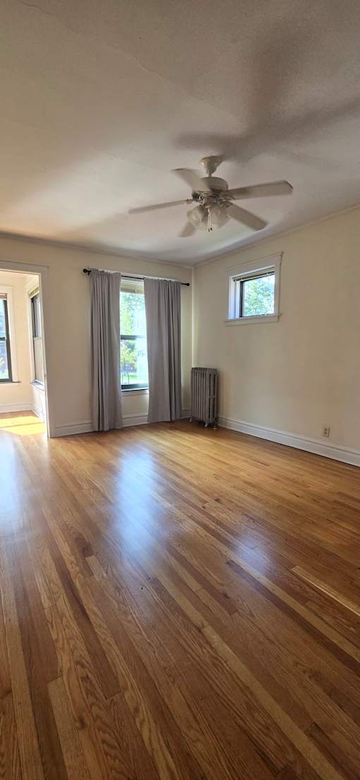 A ceiling fan is mounted on a wall in a room with wooden walls and ceiling.