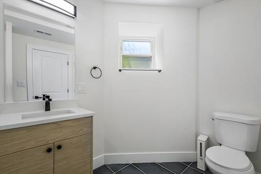A white toilet sits next to a sink in a small bathroom.