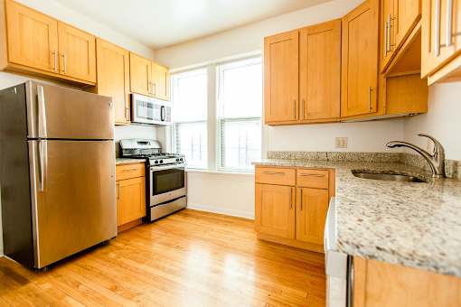an empty kitchen with wood floors and wooden cabinets