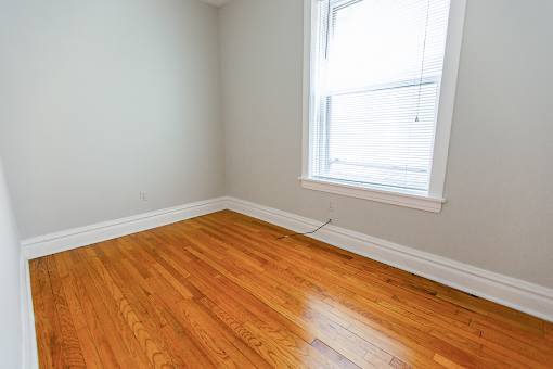 an empty room with wooden floors and a window
