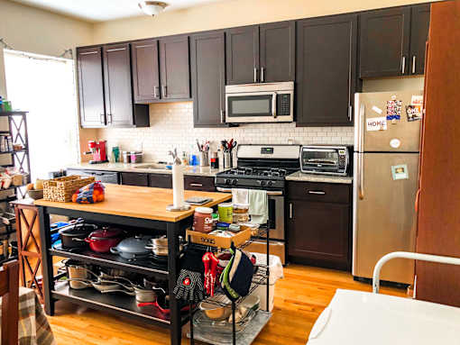 A kitchen with a refrigerator, oven, and microwave.
