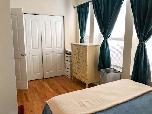 A bedroom with a bed, dresser, and wardrobe.