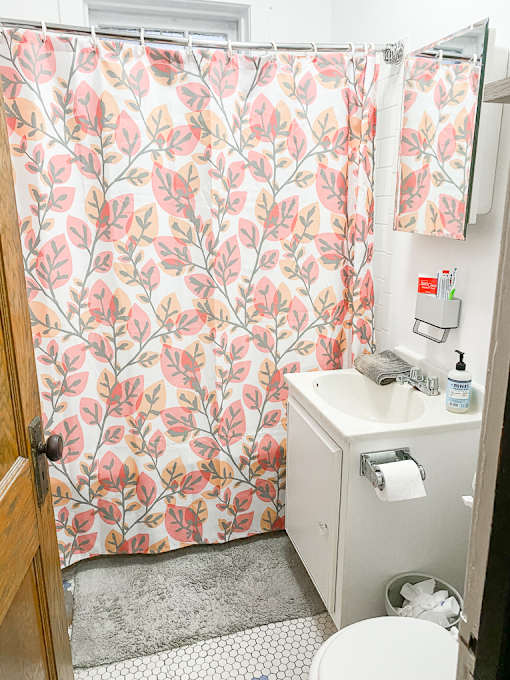 a small bathroom with a sink and toilet and a shower curtain