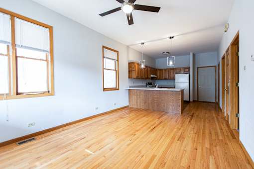 A room with wooden floors and a ceiling fan.
