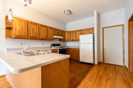 A kitchen with wooden cabinets and a white counter top.