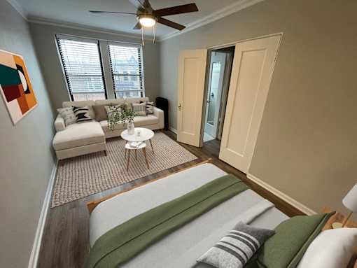 A living room with a couch, a chair, and a painting on the wall.