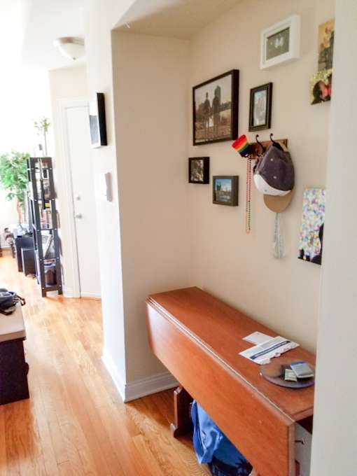 a room with a desk and a hat hanging on the wall