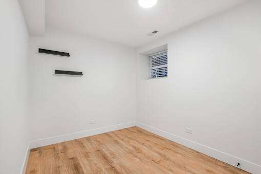 A room with wooden flooring and white walls.