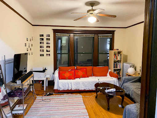 A living room with a couch, a television, a coffee table, and a rug.