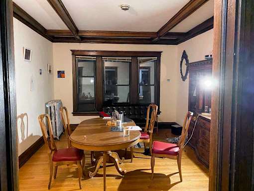 A dining room with a wooden table and chairs.